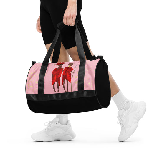  A woman holding the Agojie Topaz Overnight Gym Bag by hand, with its dual shorter straps. 